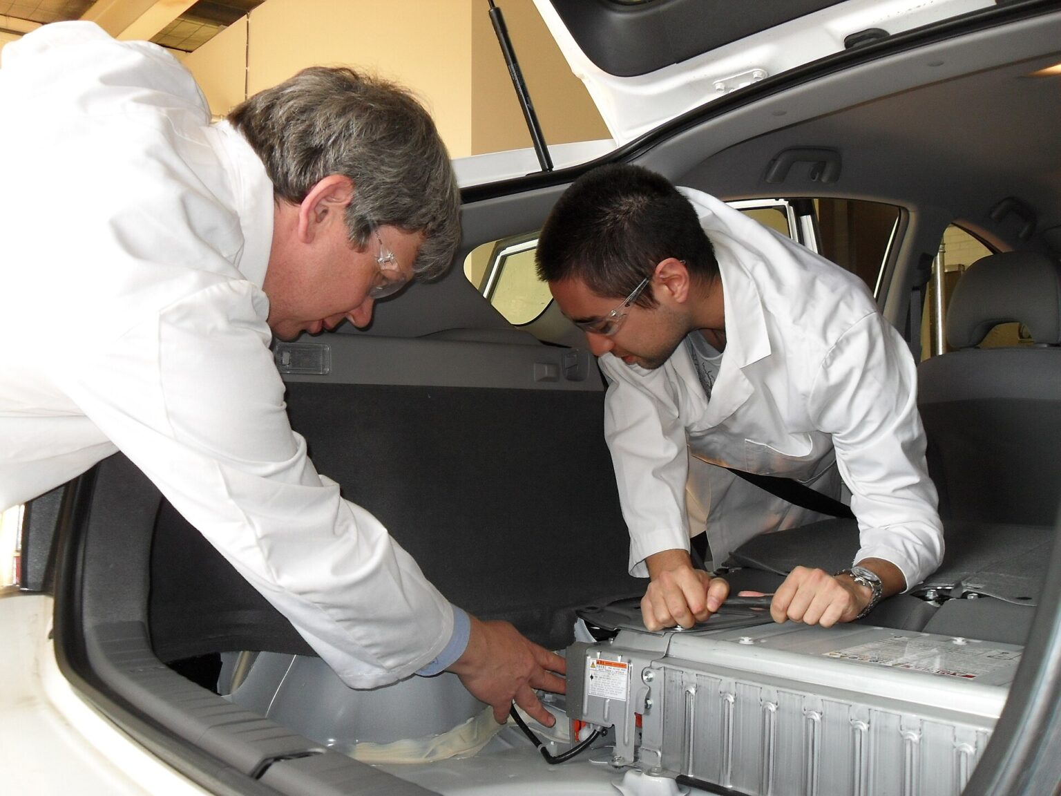 Engineers refitting a plug-in hybrid electric vehicle during battery research in Australia